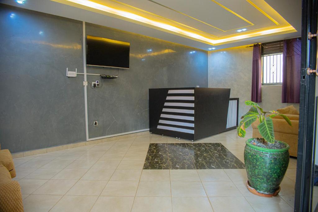 a living room with a staircase and a tv at Transit Haven in Entebbe