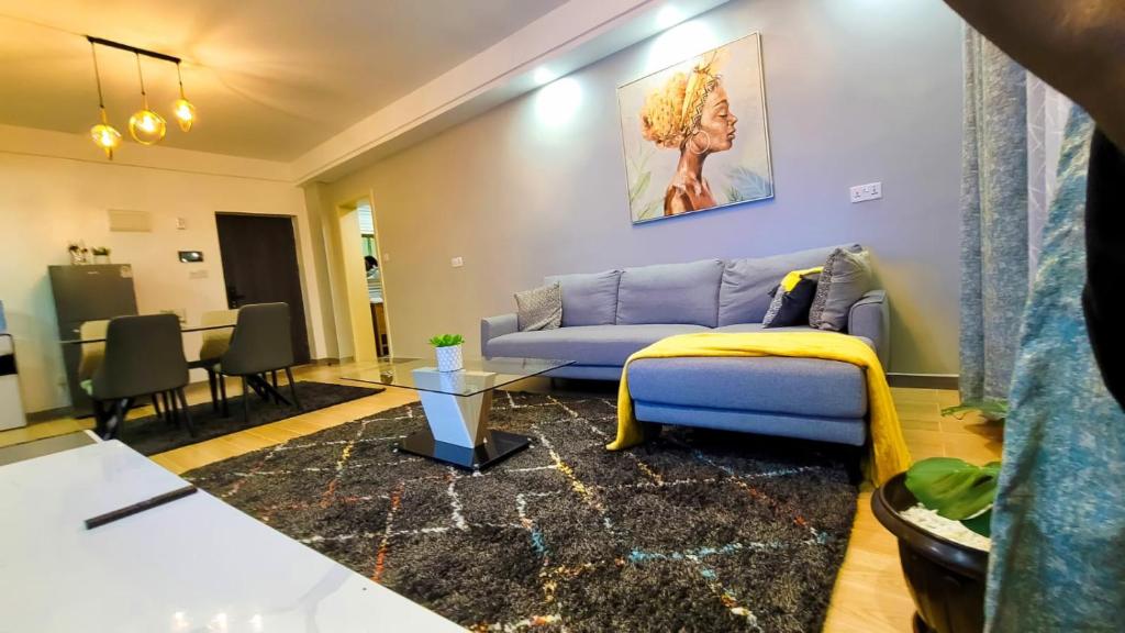 ナイロビにあるGoldpark apartmentsのリビングルーム(青いソファ、テーブル付)