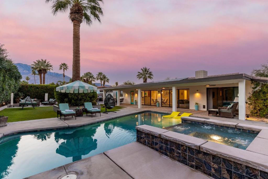 une maison avec une piscine et des palmiers dans l'établissement Villa Del Sol, à Palm Springs