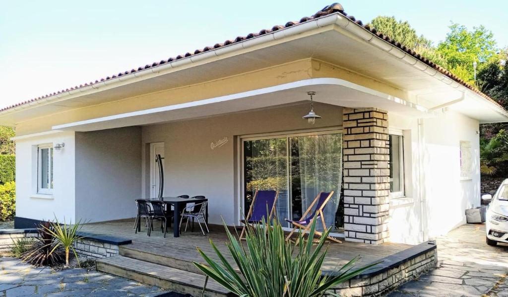 a house with a porch with a table and chairs at L&B Pereire Arcachon 6 pers, 700m plage Pereire in Arcachon