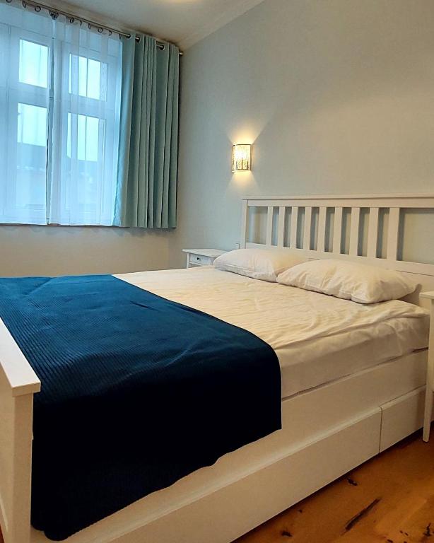 a bedroom with a large white bed with a window at Old Town Comfort in Tarnów