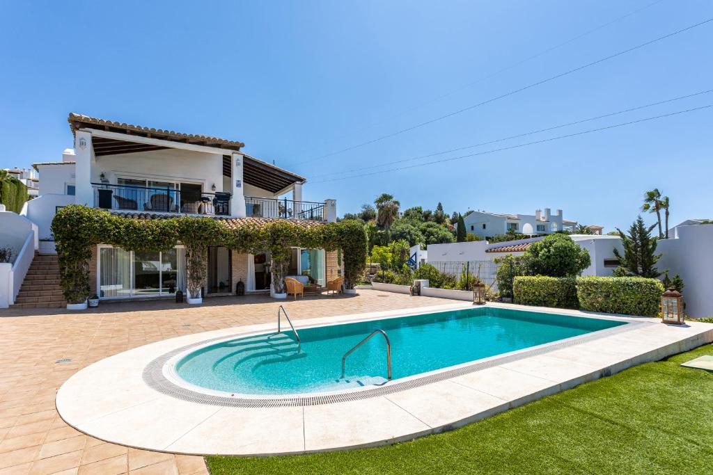 a swimming pool in front of a house at Villa Pugna - Private Pool, BBQ, Sauna in Benalmádena