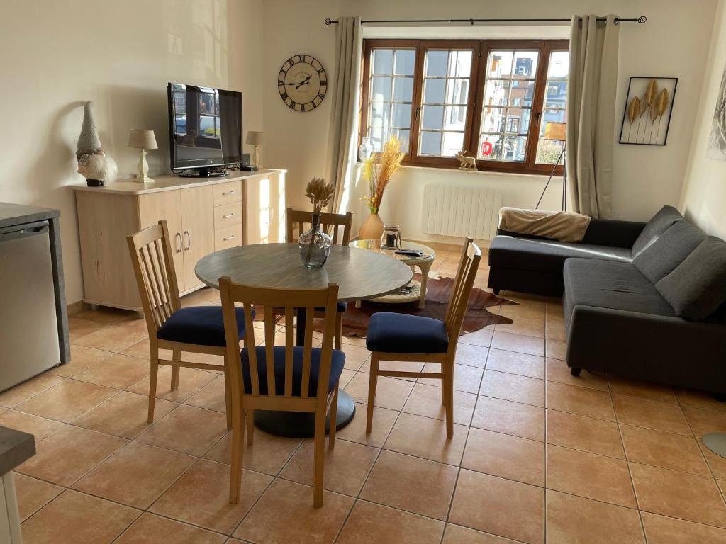 a living room with a table and chairs and a couch at Appartement Mac Auliffe in Bastogne