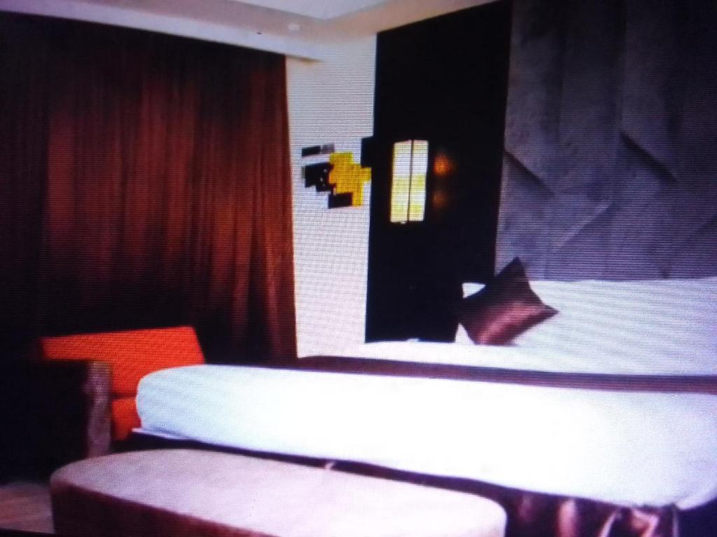 a room with a bed and a table and chairs at Villa toscana luxe hotel and suites in Port Harcourt