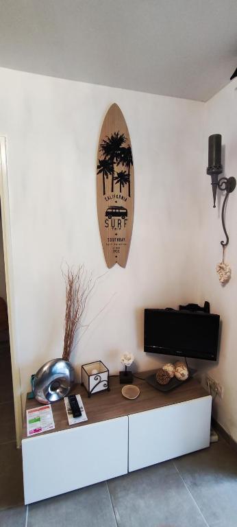 un salon avec une planche de surf sur le mur dans l'établissement Studio Cabine La Grande Motte, à La Grande Motte