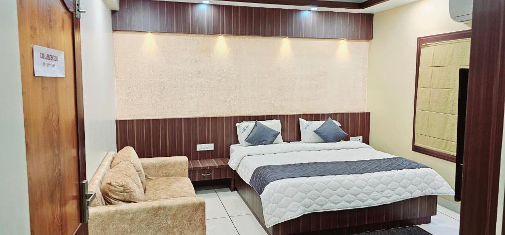 a bedroom with a bed and a chair at Hotel Royal Wings in Elūr
