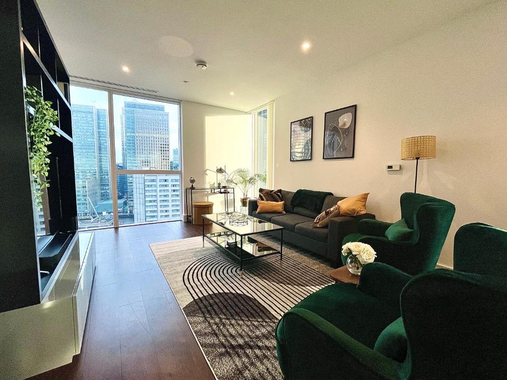 ein Wohnzimmer mit einem Sofa und einem TV in der Unterkunft Luxury Modern 2 Bed Flat with Balcony + City View - Canary Wharf City Center in London