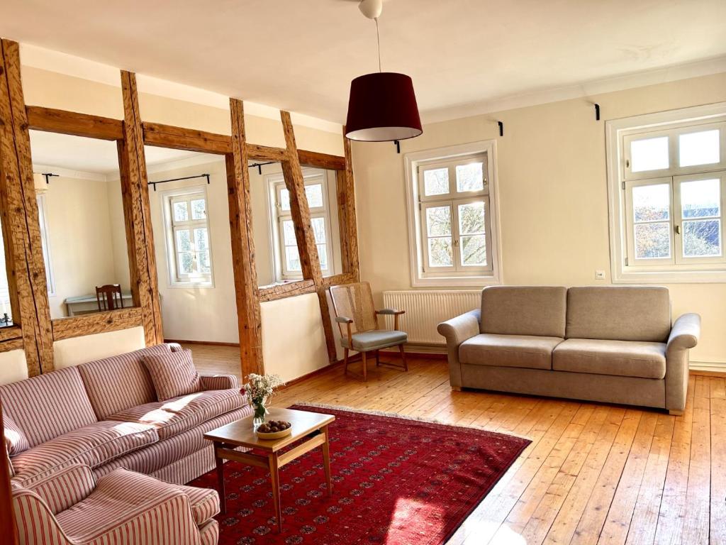 a living room with two couches and a table at Ferienwohnung Schloss Heldritt in Bad Rodach
