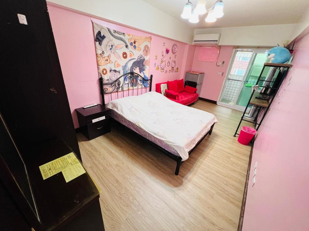 a bedroom with a bed and a red chair at ZhengXing in Tainan