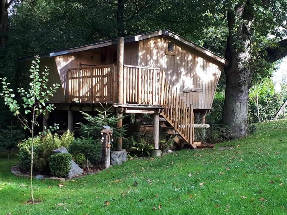 a tree house with a deck in a yard at La cabane perchée du trappeur in Écrainville