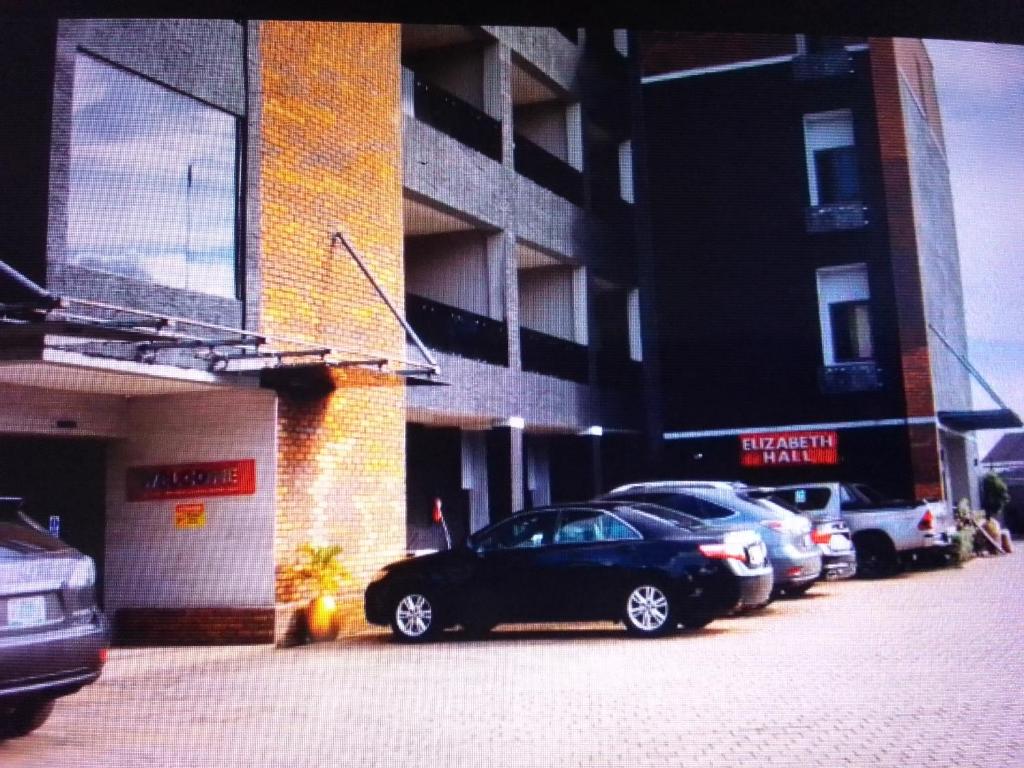 a parking lot with cars parked in front of a building at VILLA TOSCANA asaba in Okpanam
