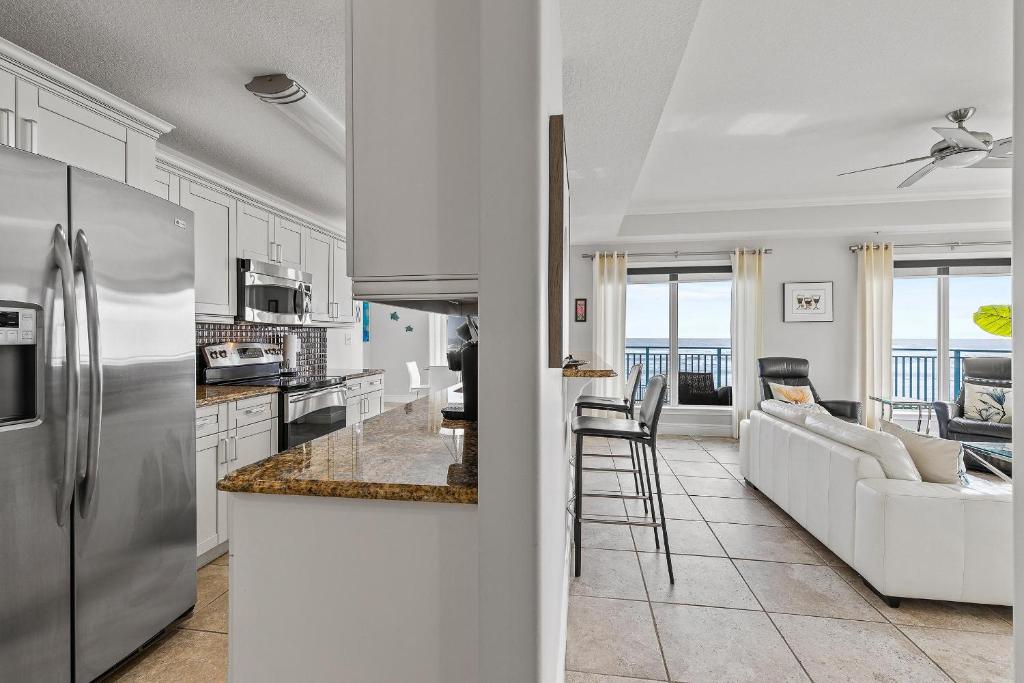 a kitchen and living room with a stainless steel refrigerator at The Wave 302 in New Smyrna Beach