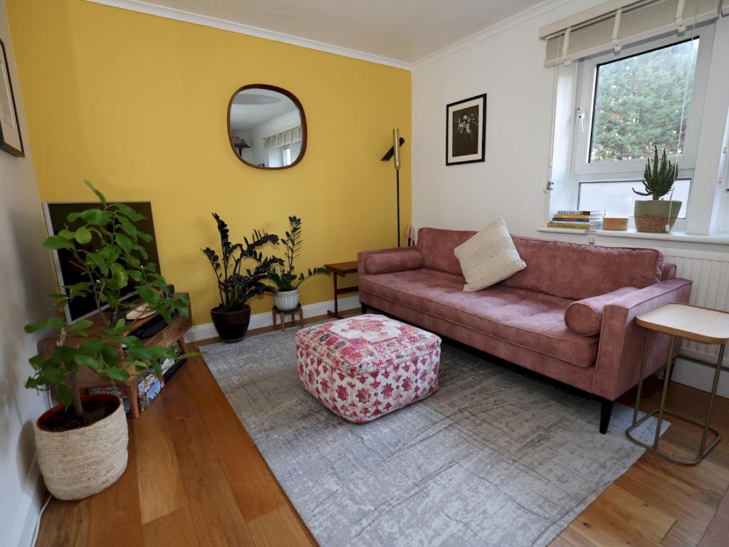 a living room with a couch and a mirror at Pass the Keys Charming 2 bed apartment in London