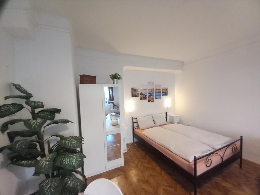 Un dormitorio con una cama y una planta. en Budapest A+ Apartment, en Budapest
