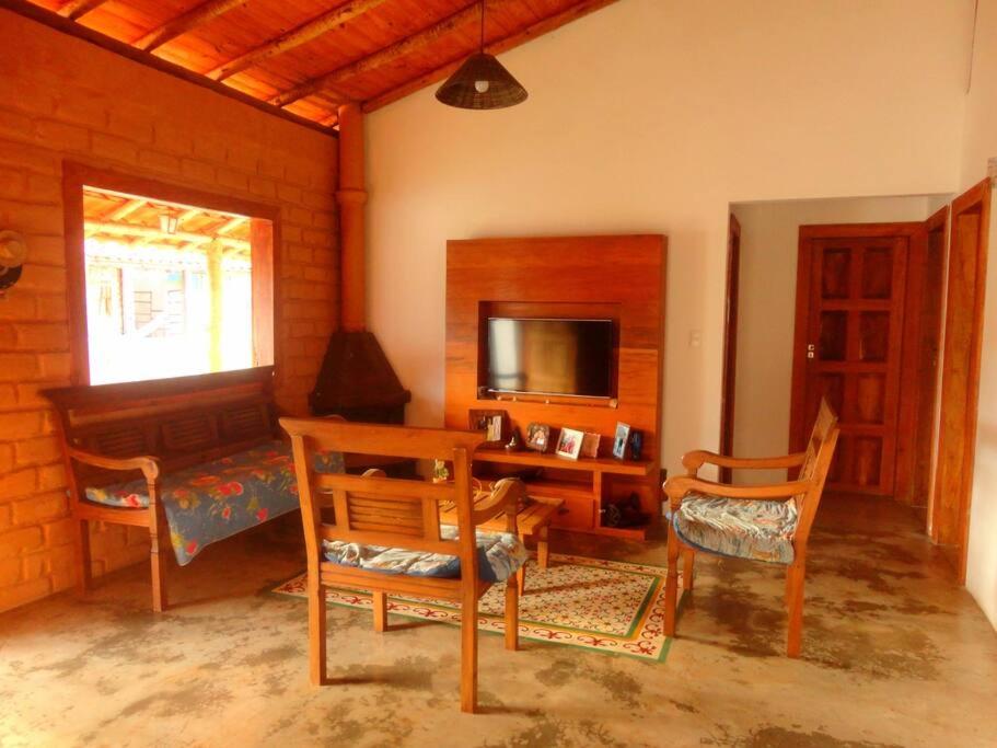 - un salon avec une table, des chaises et une télévision dans l'établissement Casa ¨La Linda¨ - Milho Verde MG, à Milho Verde