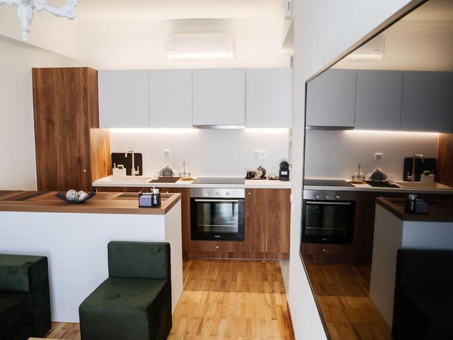 a kitchen with wooden floors and a green chair at Filigran II-Stylish Apartment with Free Parking in Ioannina