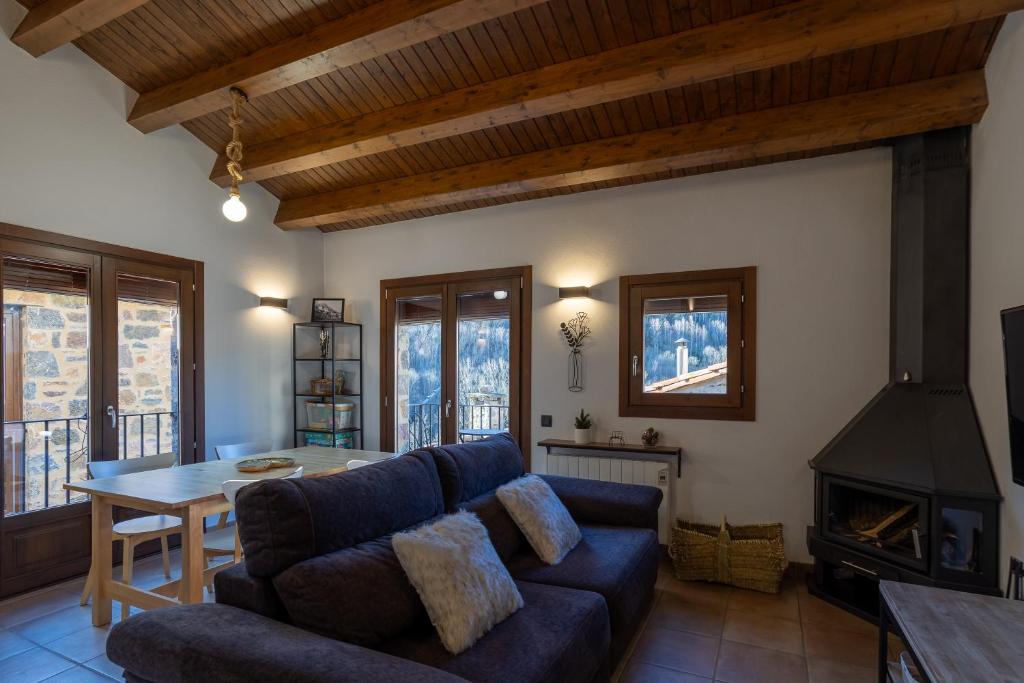 ein Wohnzimmer mit einem blauen Sofa und einem Tisch in der Unterkunft Lo Petit Refugi in Camprodon
