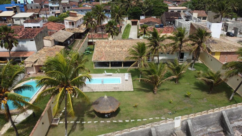 an aerial view of a house with a pool and palm trees at Villa Riacho Doce in Maceió