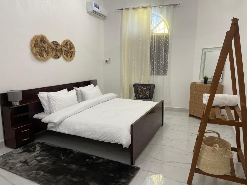 um quarto com uma cama com lençóis brancos e uma janela em Nashu House Stone Town em Ngambo