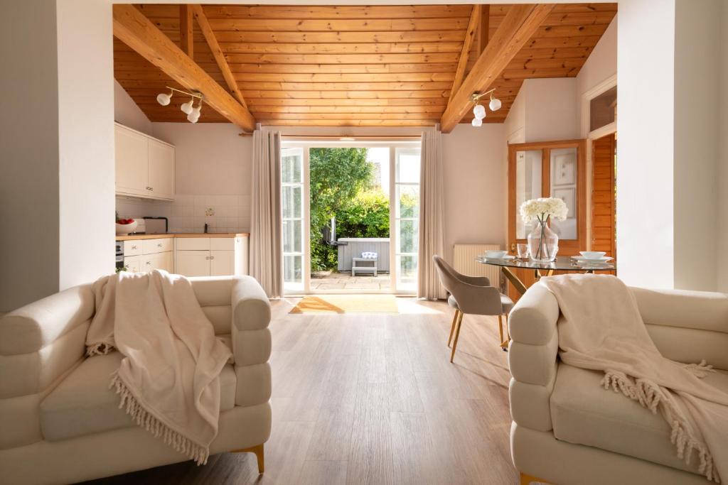 a living room with two chairs and a table at Snowdrop - Connect to the Nature in the Hot Tub in Blandford Forum