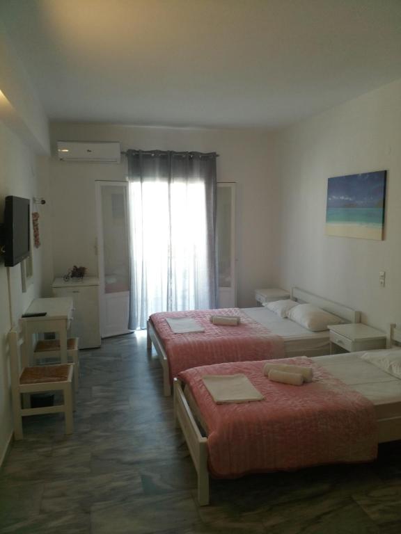 a hotel room with two beds and a window at Frangiscos in Parikia