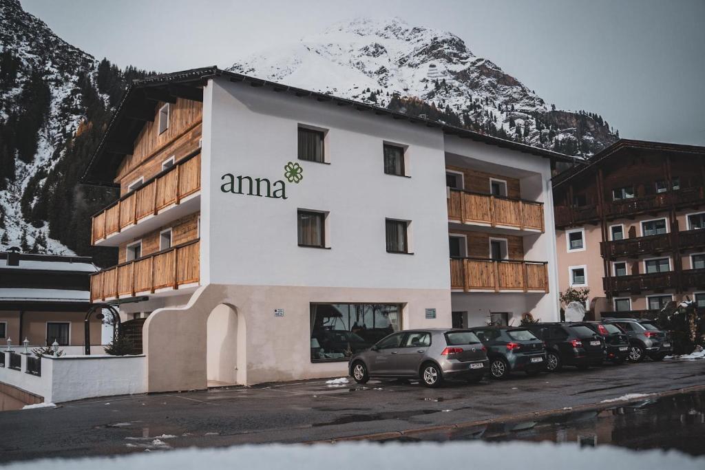 ein Gebäude mit Autos auf einem Parkplatz in der Unterkunft Pension Anna in Sankt Leonhard im Pitztal