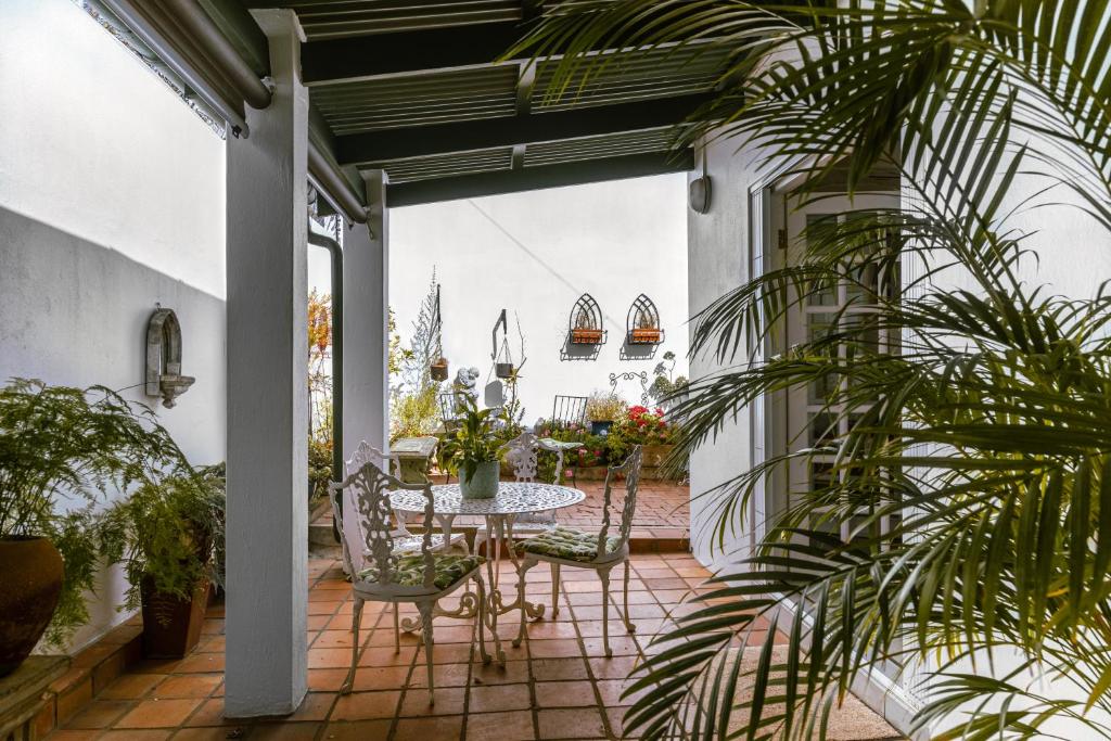 a patio with a table and chairs and plants at Fig Tree in Pretoria