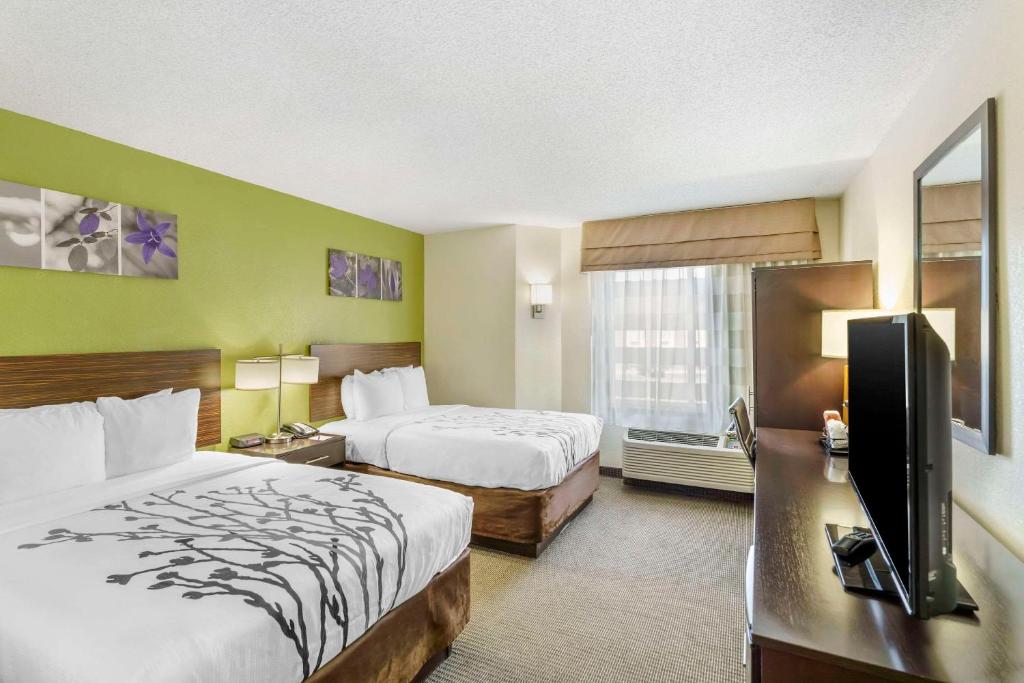a hotel room with two beds and a flat screen tv at Sleep Inn in Hickory