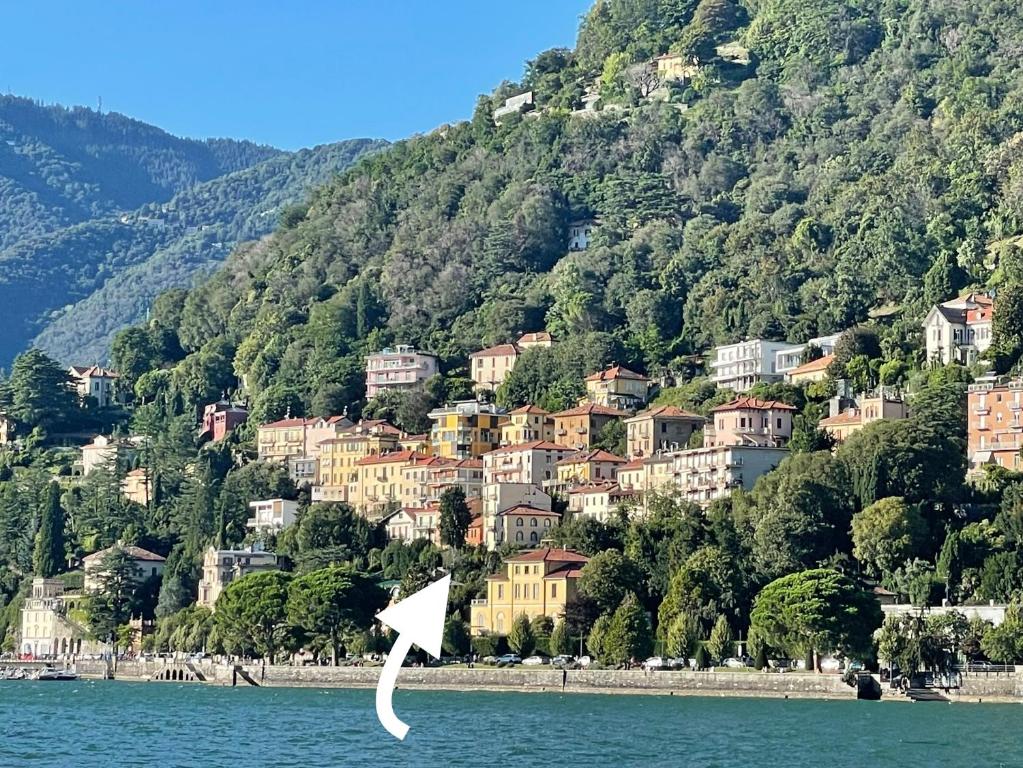 a white kite flying over the water in front of a mountain at Lake Front View on Viale GENO in Como