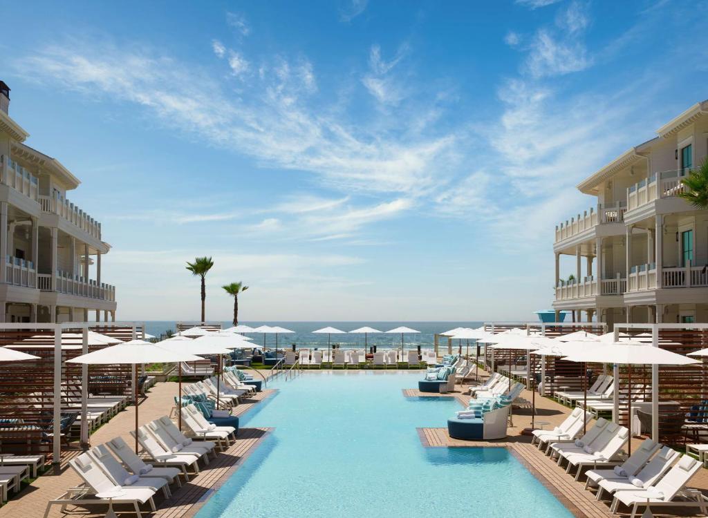 圣地亚哥Shore House at The Del, LXR Hotels & Resorts的配有躺椅和遮阳伞的游泳池