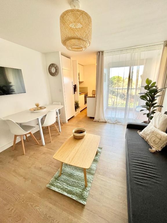 un soggiorno con divano e tavolo di Appartement Cosy - Cap d'Agde proche plage et port - Parking a Cap d'Agde