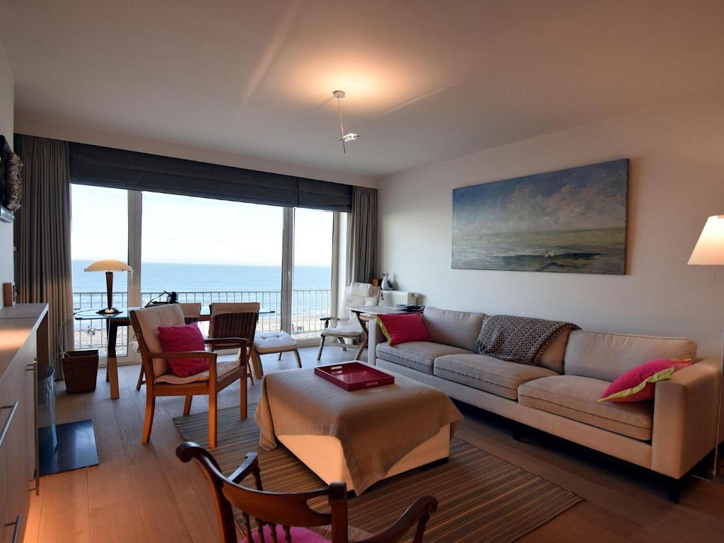 a living room with a couch and a table at Golden beach 0203 with sea-view in De Haan in De Haan