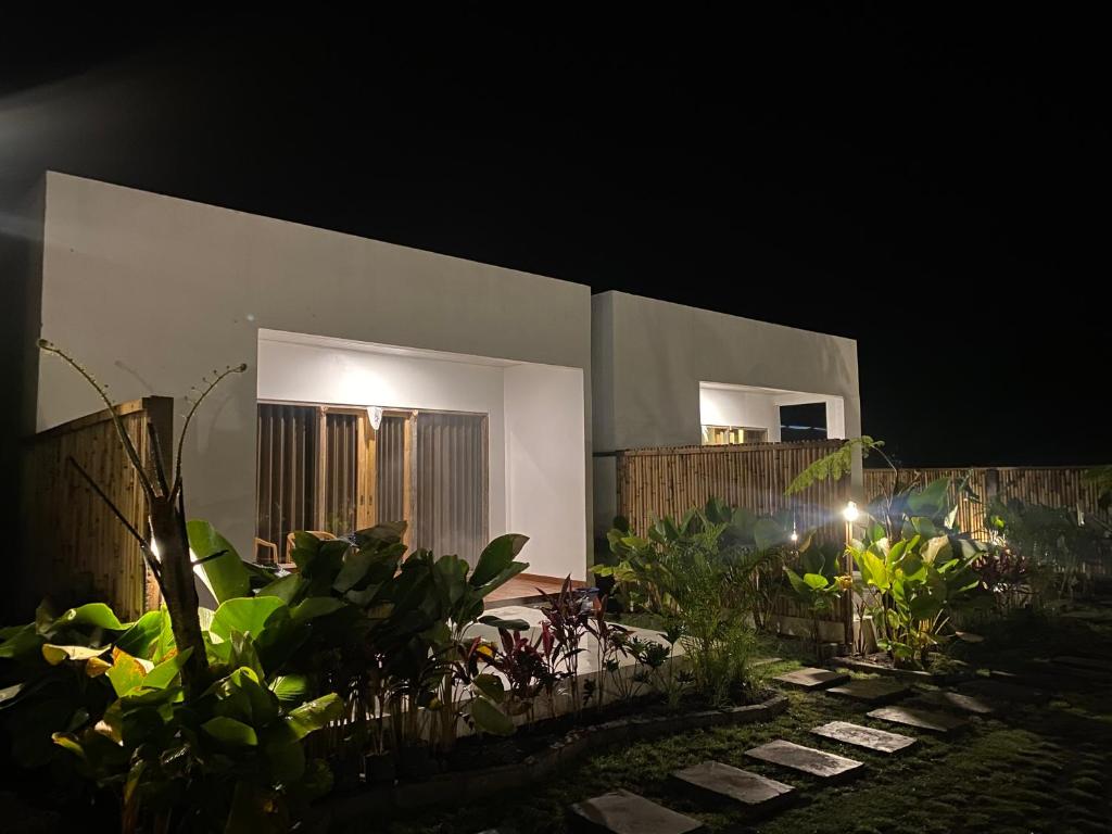 un edificio con dos ventanas y una valla por la noche en Brahmastra Bali villa en Kubupenlokan