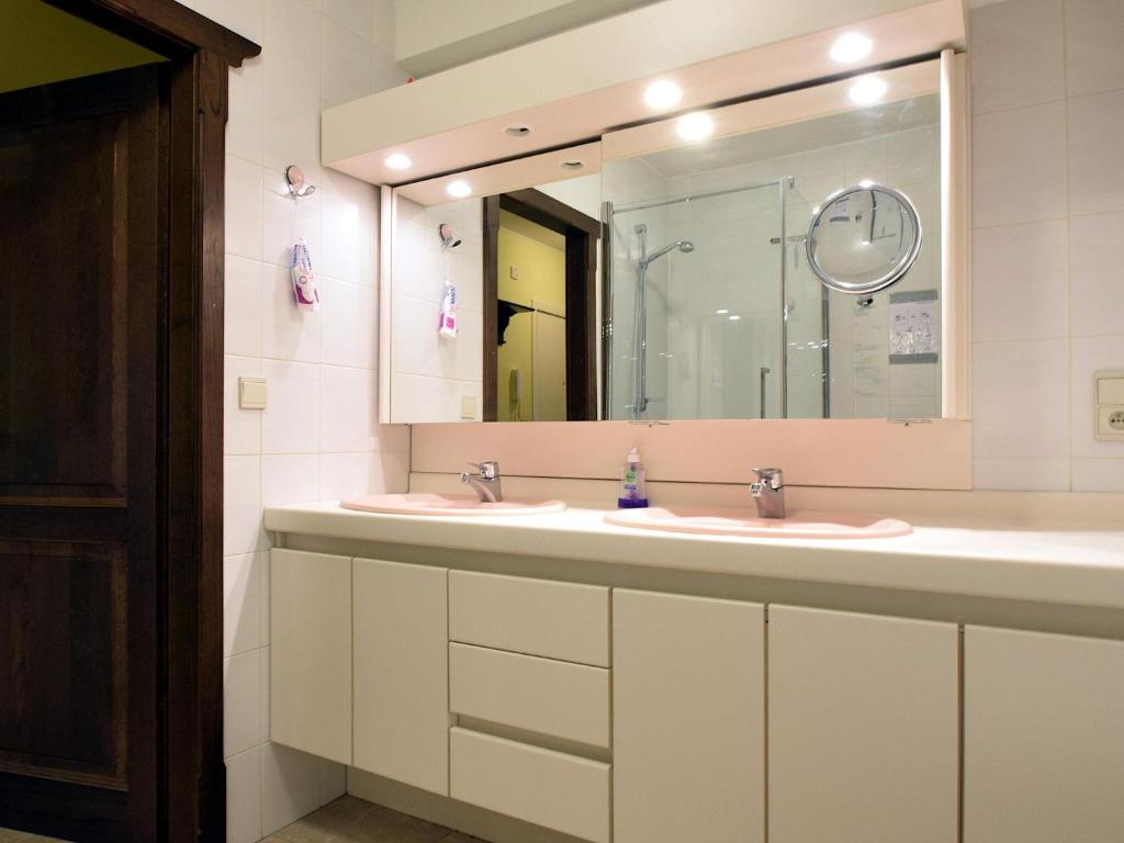 a bathroom with two sinks and a large mirror at Blomme 0202 exclusive apartment with sea view in De Haan