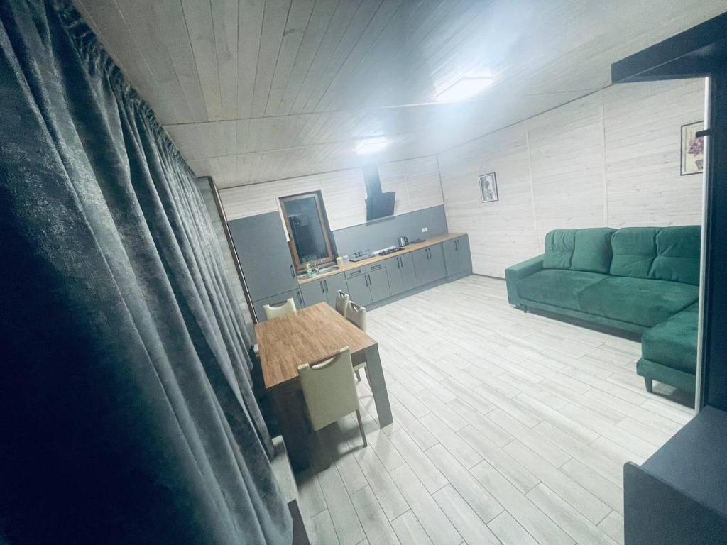- un salon avec un canapé vert et une table dans l'établissement Гостевой комплекс "Дядя Саша", à Sokirno