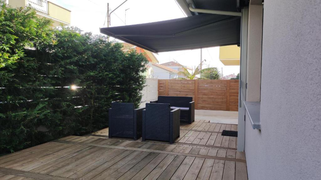 - une terrasse avec 2 chaises et un parasol dans l'établissement Potenza Suite Home, à Riccione