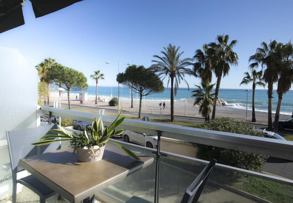 a balcony with a table and a view of the beach at Tiercé Hotel in Cagnes-sur-Mer