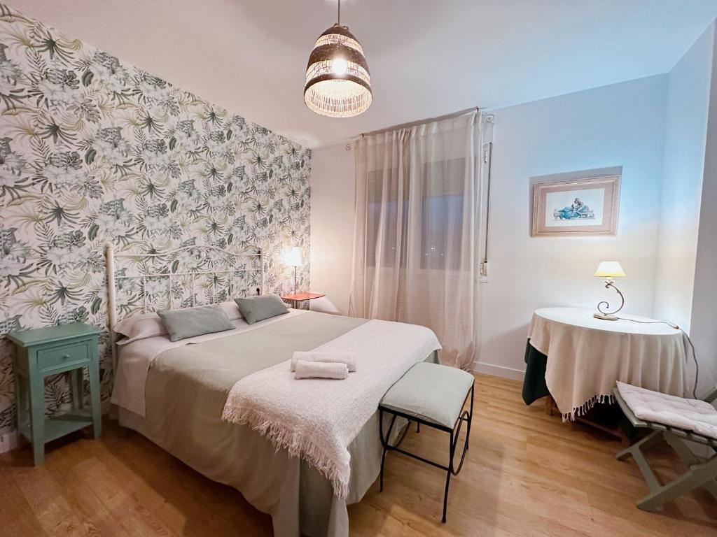 a bedroom with a large bed and a table at Apartamento Suite Los Deportes in Ponferrada