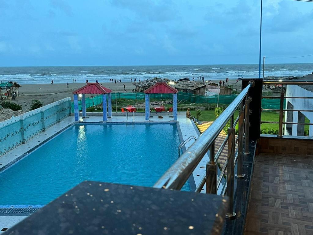 a swimming pool with a view of the beach at Sea Queen Beach Resort On Beach in Mandarmoni
