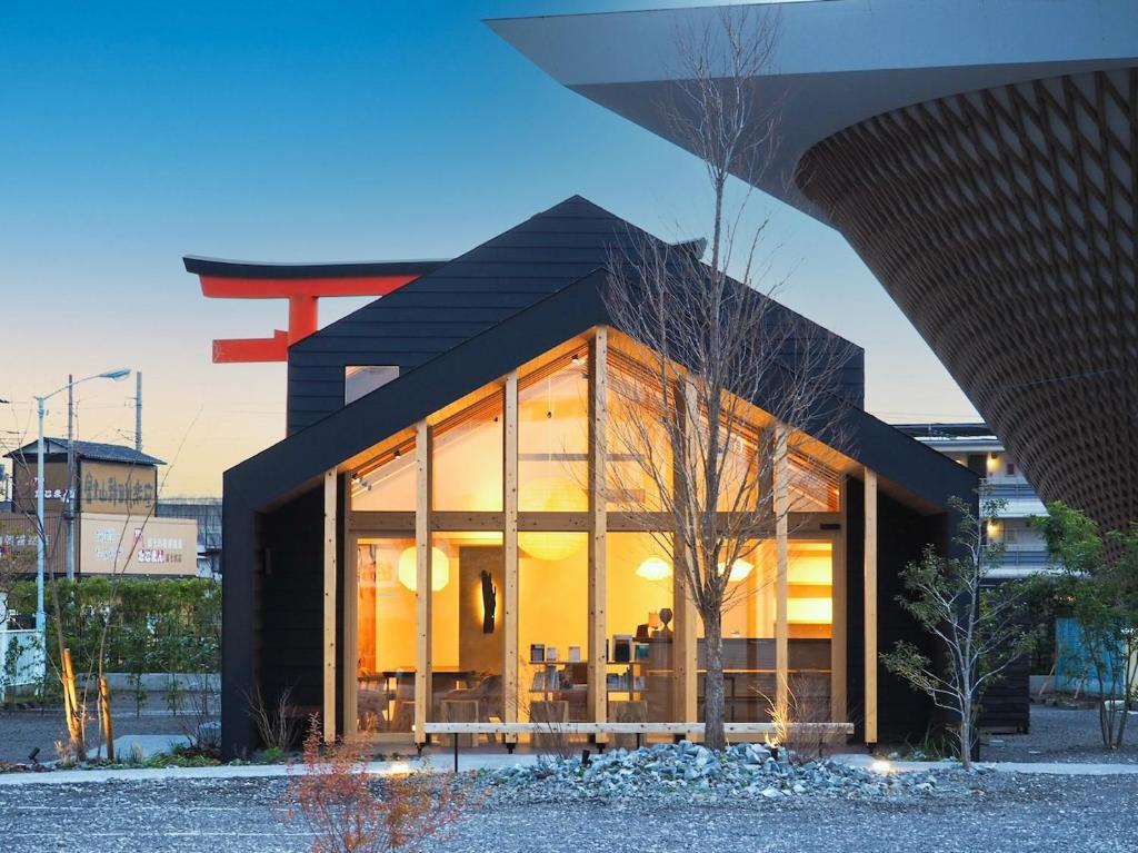 a house with large glass windows in a city at MUKUten舎富士宮 MUKUtensha Fujinomiya natural wood retreat hotel in Fujinomiya