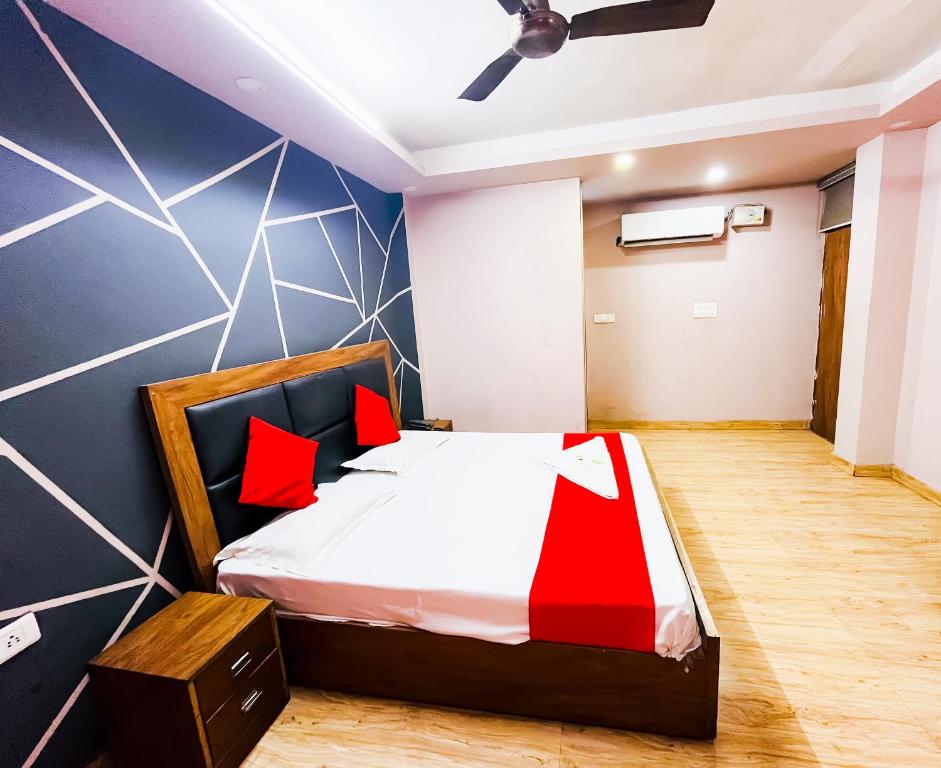 a bedroom with a bed with red pillows at Comfort Inn Nizamuddin Railway Station 2 Min Walk in New Delhi