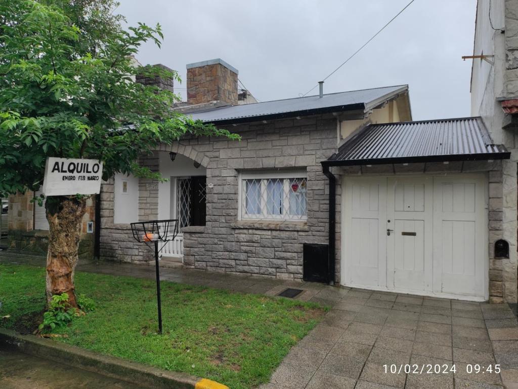 una casa con un garaje y un cartel delante en Alquiler Temporada Casa 2 dormitorios para 6 personas en Mar del Plata
