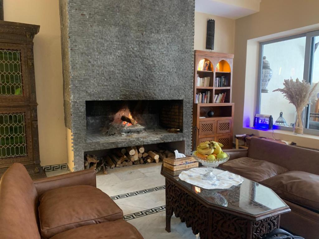 a living room with a fireplace with a couch and a table at Ksar Anika Boutique Hotel & Spa in Marrakech