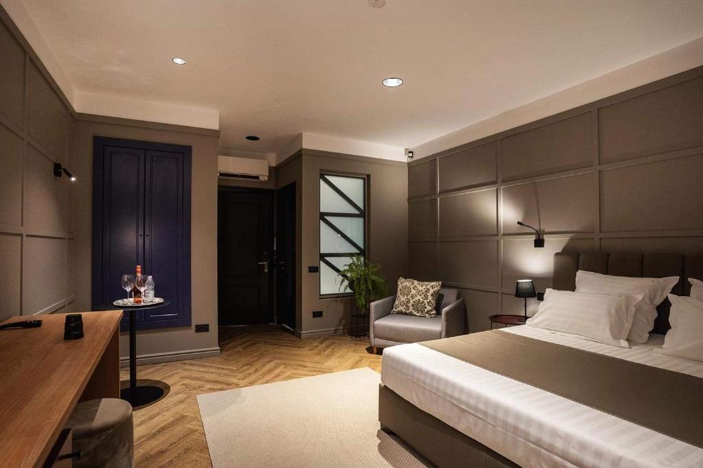 a bedroom with a bed and a desk and a chair at Boutique ALNIS in Constanţa