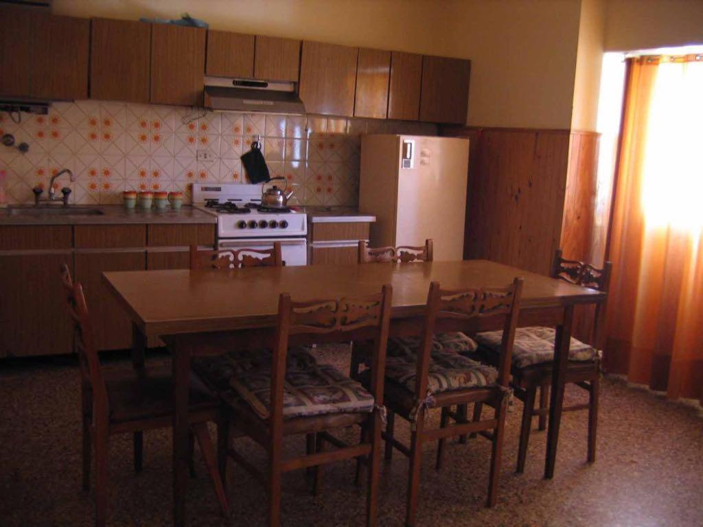 cocina con mesa, sillas y nevera en La soñada en Mar de Ajó