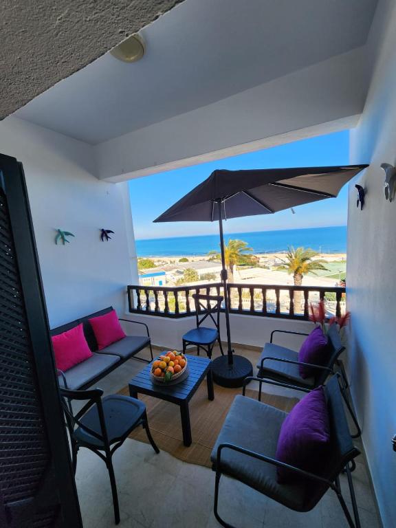 a living room with a view of the beach at L'univers de la mer appartement in Douar el Hafey