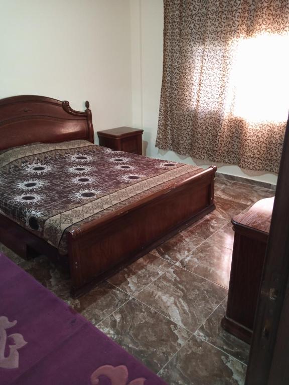 um quarto com uma cama e uma janela em الشقة العائلية الحديثة em Amã
