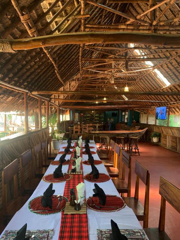 einen langen Tisch mit schwarzen Vögeln, die oben drauf sitzen in der Unterkunft Patamu Restaurant & Lodge in Karatu