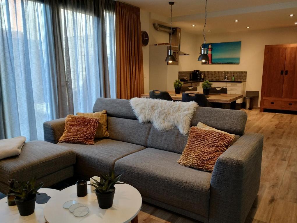 a living room with a couch with pillows on it at Aan't Strand Bed by the Sea Adults only in Westkapelle