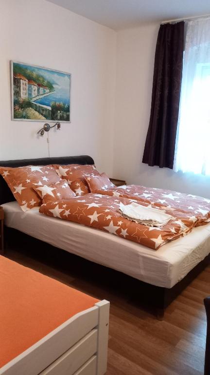 a bedroom with a bed with a brown comforter at Szép-Lak Makó in Makó